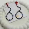 Product Description Triple the Guardian Energy, Unmatched Artisan Shine. Give your little one the ultimate shield of safety and style with the KJJ Elite Triple Evil Eye Nazariya. This premium set features three vibrant blue evil eye charms per bracelet, strategically placed to offer maximum spiritual protection from every angle. These sacred charms are beautifully paired with 2.5mm imported chevron-textured silver balls, which feature intricate "V" patterns designed to catch and reflect light with every tiny movement. Handcrafted with certified 92.5 Sterling Silver, these bracelets are meticulously hand-strung on a soft, durable black cord with polished black beads to ward off negative energy. Designed specifically for sensitive infant skin, this set ensures your baby remains shielded with high-quality materials and a touch of modern, textured luxury. Key Highlights: Triple Evil Eye Protection: Features three distinct blue evil eye charms on each bracelet for enhanced spiritual safeguarding and a bold, festive look. Chevron-Textured 2.5mm Beads: Includes premium imported silver balls with an artistic faceted texture that provides superior brilliance compared to standard smooth beads. Certified 92.5 Sterling Purity: Every silver component is made from guaranteed high-purity silver, ensuring it is hypoallergenic, lead-free, and safe for newborns. Signature Tassel Finish: Finished with our iconic red and black artisan tassel, adding a traditional touch while providing a secure, adjustable fit for growing wrists. A Meaningful Blessing: An ideal choice for "Namkaran" (naming ceremonies), first birthdays, or as a protective homecoming gift from loved ones. Product Specifications: Brand: Kanhaji Jewels (KJJ) Material: 92.5 Sterling Silver & High-Grade Protective Beads Silver Ball Texture: 2.5mm Chevron-Cut (Imported) Category: Infant Protection Jewelry / Nazariya Quantity: 1 Pair (Set of 2)